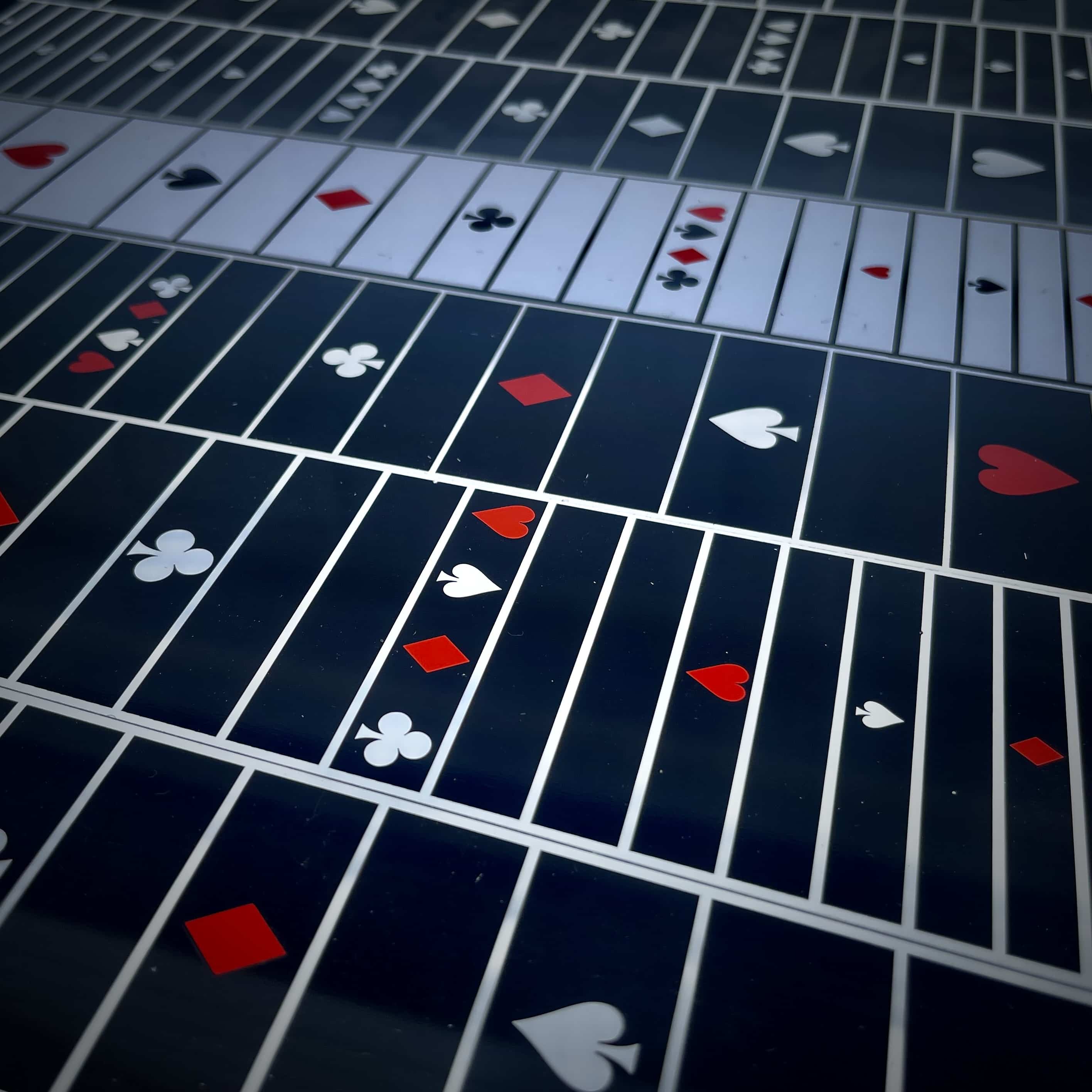 Playing card suits on a grid surface.